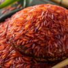 Zoomed-in image of organic red rice grains showcasing their texture and vibrant color